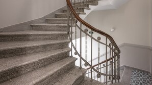 Egy spirál lépcső, kőből készült lépcsőfokkal és fa korláttal, amely a felső szintre vezet.