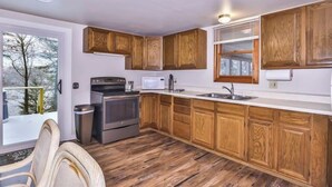 Une cuisine avec des meubles en bois, un four à micro-ondes, une cuisinière et un évier.