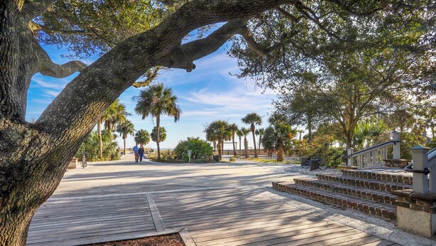 A wooden boardwalk leading to a beach area with palm trees and a staircase. - Tanglewood 101 - South Forest Beach 1 Block From the Ocean (Hilton Head Island)