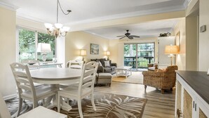 A spacious living room with a dining area, a ceiling fan, and a view of the outdoors. - Tanglewood 101 - South Forest Beach 1 Block From the Ocean (Hilton Head Island)