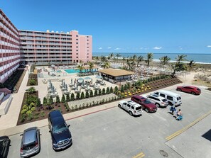 A hotel with a pool area, outdoor seating, and a view of the ocean.