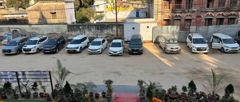 A parking lot with several cars and potted plants.