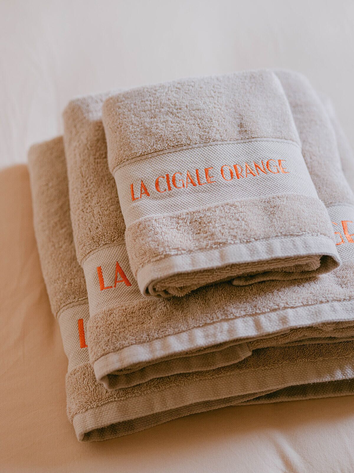 A stack of folded towels with embroidered text.