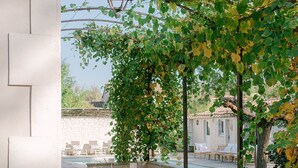 An outdoor dining area with a pergola, tables, and chairs.