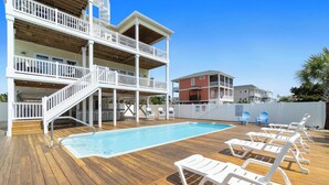 A multi-story building with a pool and outdoor seating area.