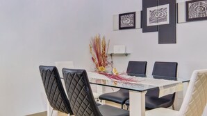 A dining area with a glass table, black and white chairs, and abstract wall art. - Casa Verde, located in the village Artatore, 150 m distance from the sea, for 5 people. (Cunski)