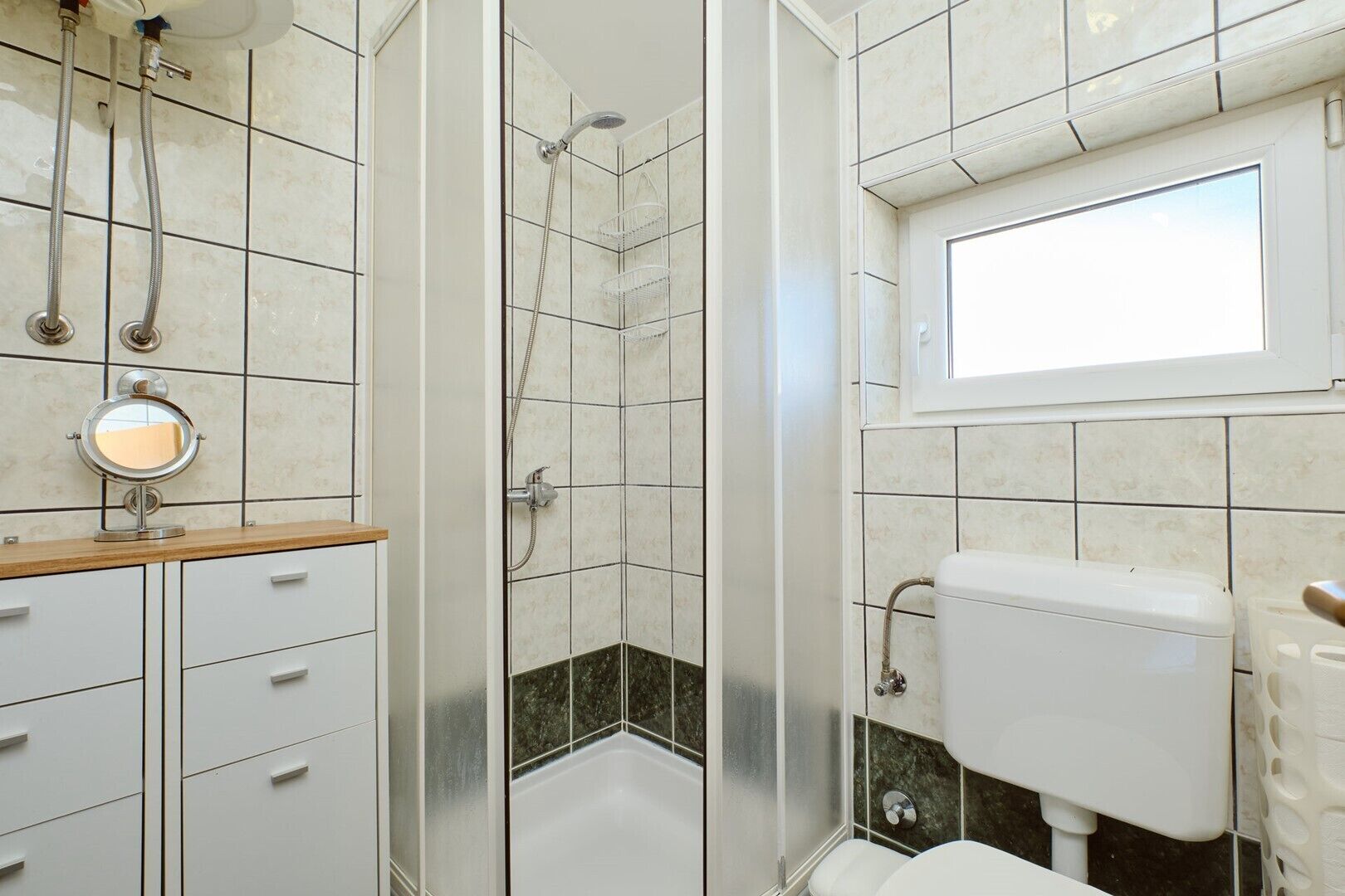A bathroom with a shower, toilet, and sink.