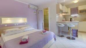 Ein Hotelzimmer mit Bett, Bad und Küchenzeile.