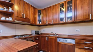 A kitchen with wooden cabinets, a microwave, a dishwasher, and a gas stove. - Apartment Dino 1, situated on the ground floor, ideal for four people. (Mali Lošinj)