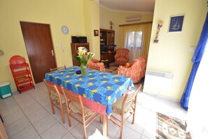 A dining area with a table covered in a blue tablecloth with lemon patterns, surrounded by wooden chairs. - Apartment Franka 1, accommodation of 84 m2, also offers a terrace and private parking. (Mali Lošinj)