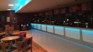 Ein Innenbereich mit Bar, Theke, Sitzgelegenheiten und gefliestem Boden.