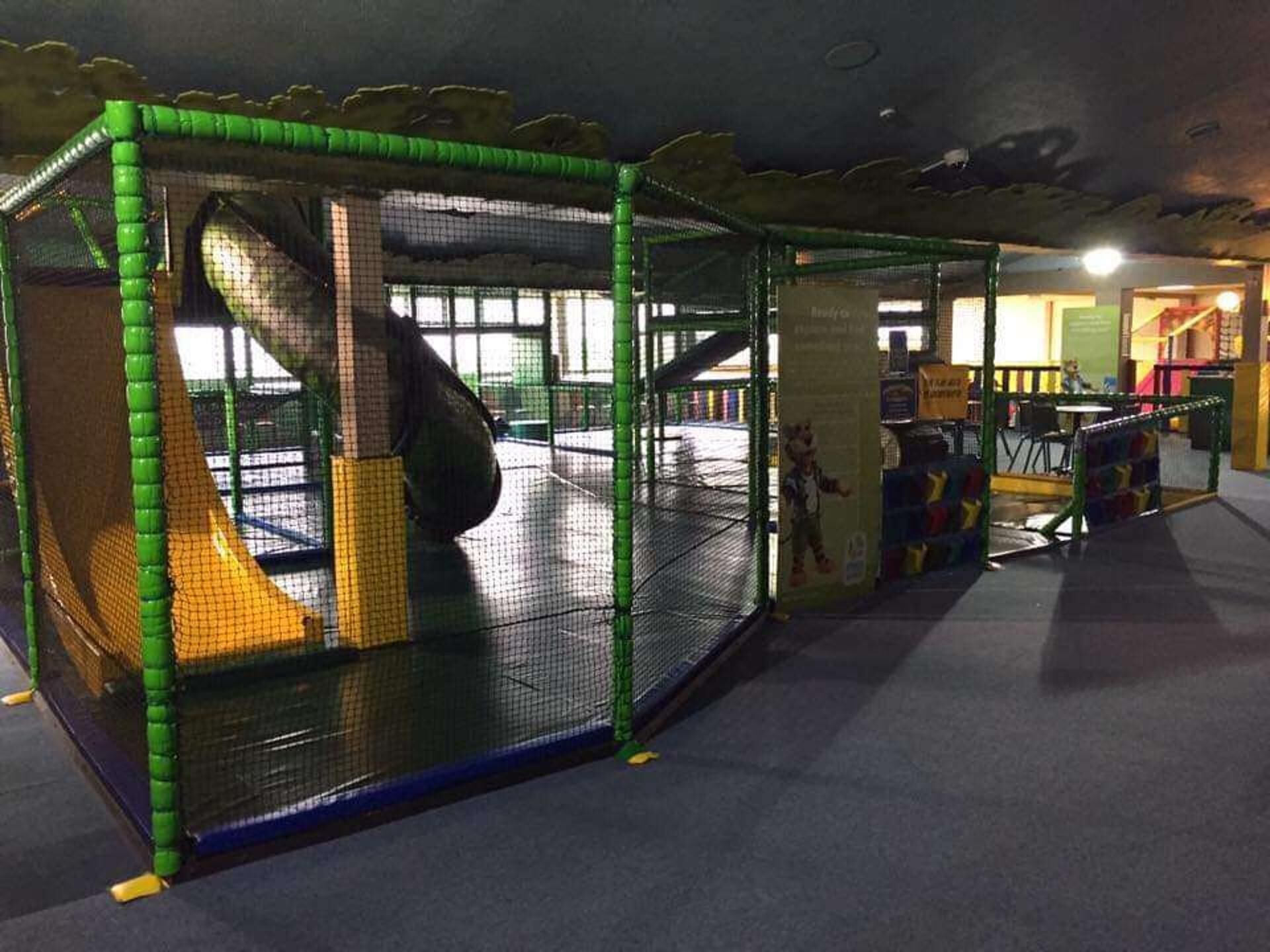 A play area with a slide and netted play structures.