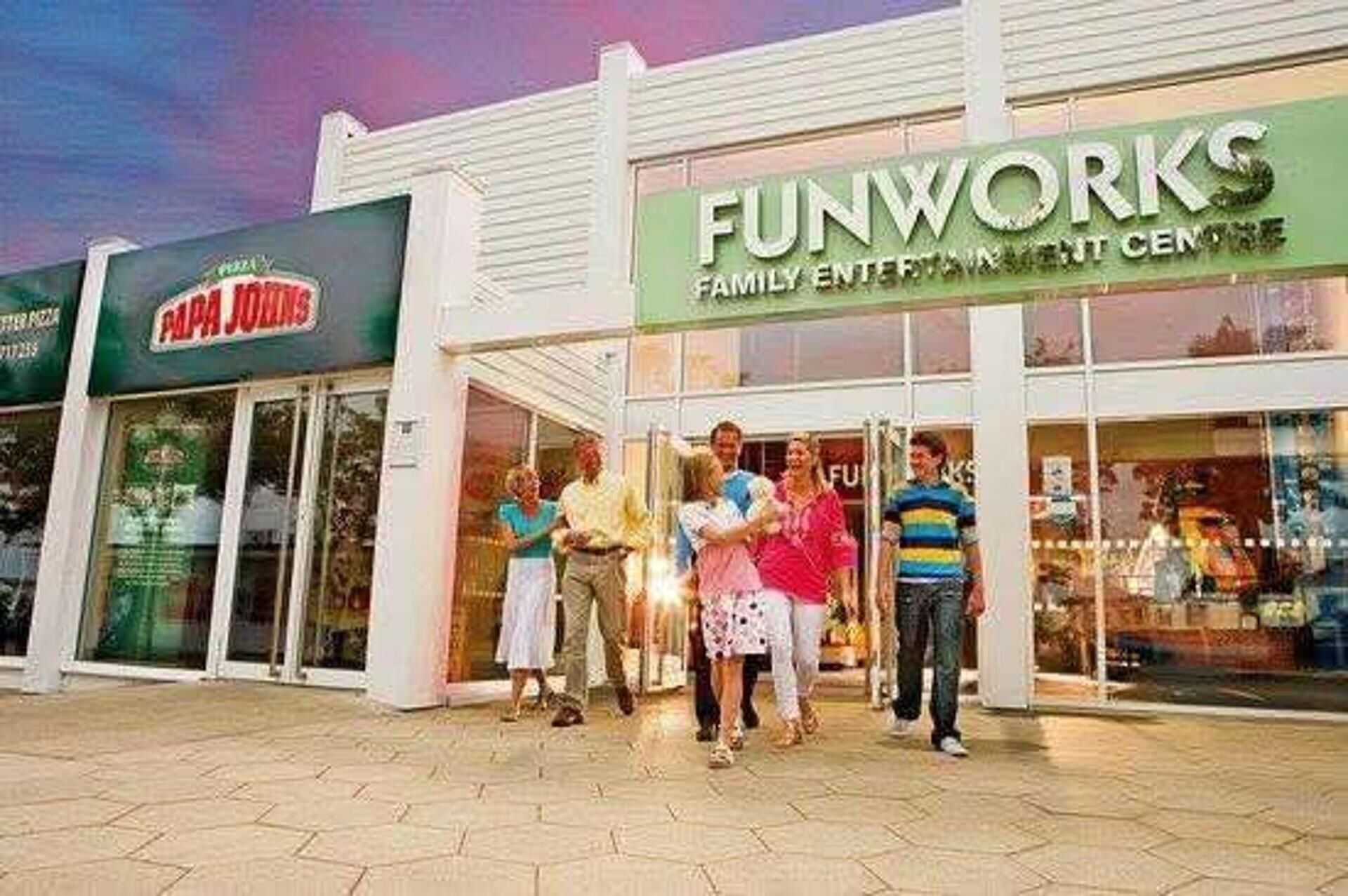 Un centre de divertissement familial qui comprend un restaurant Papa John's situé à côté.