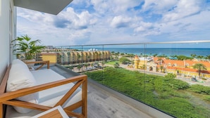 A balcony with a view of the ocean and a cityscape.