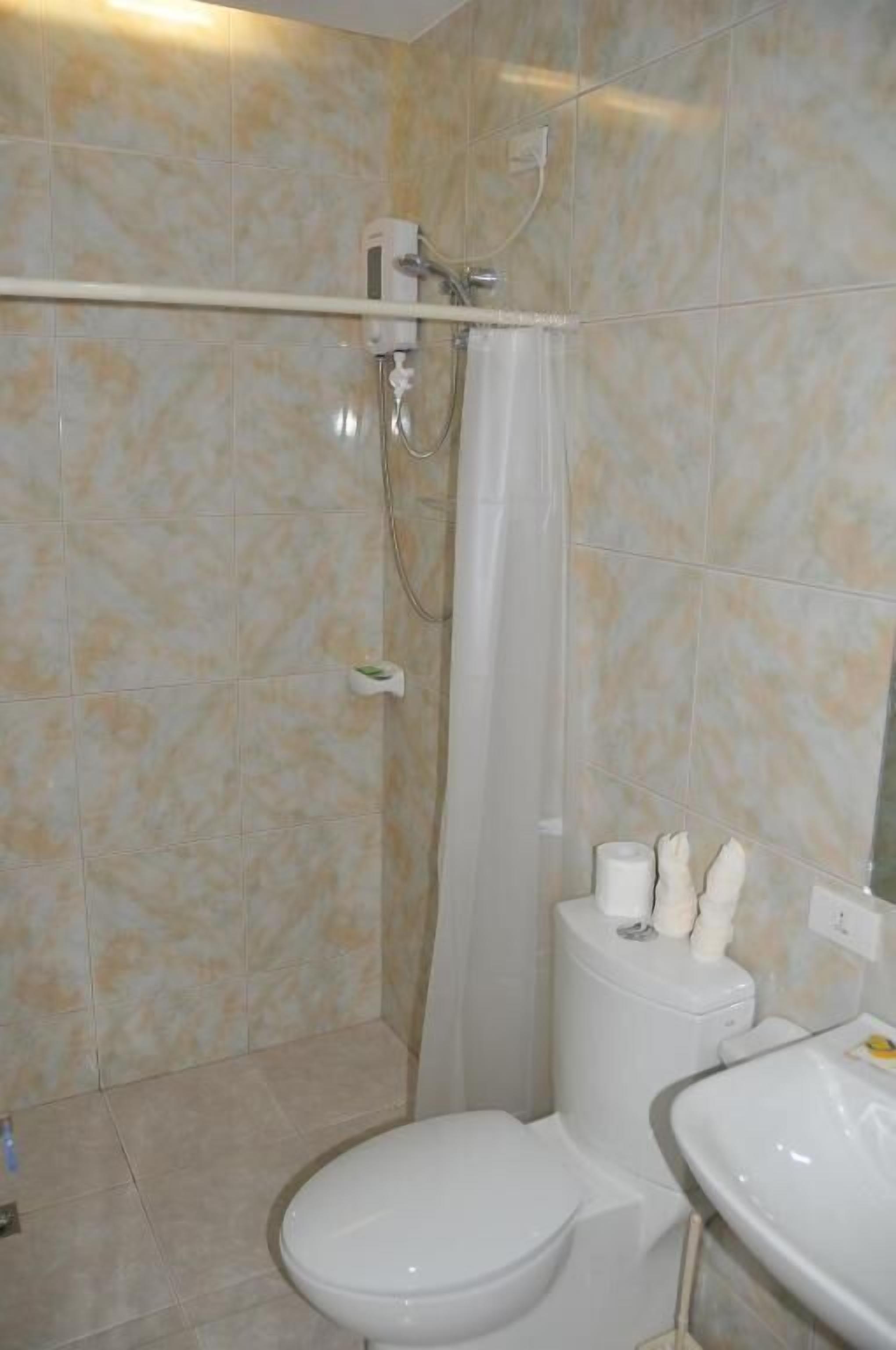 Un baño con inodoro, ducha y lavamanos.