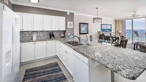 A modern kitchen with white cabinets, granite countertops, and a built-in dishwasher. - Island Princess 604 Beachfront Luxury with Stunning Gulf Views! (Fort Walton Beach)