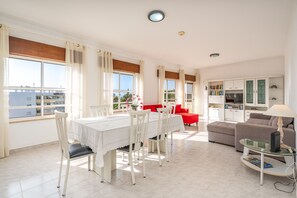 Un grand espace de vie comprenant une table à manger, des chaises, un canapé et un téléviseur.