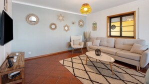 Una sala de estar con sofá, mesa de centro y espejos decorativos en la pared.
