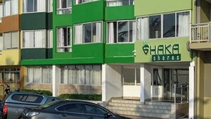 En flervåningsbyggnad med en grön fasad och en skylt som visar texten ”SHAKA shores”.