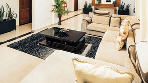 Ein modernes Wohnzimmer mit einer Couch, einem Couchtisch und Topfpflanzen.