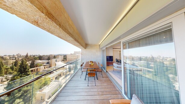 A balcony with a table and chairs, a glass railing, and a view of the city. - ♦King David Residences♦Stunning 2-Bdr with Balcony & Views♦ (Jerusalem)