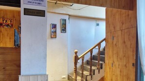 A staircase leading to a second floor with a sign indicating free WiFi and a no-washing-clothes policy. - White Villa (Shimla)