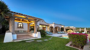 Un espace extérieur bien aménagé, comprenant une terrasse, une piscine, des chaises longues et une pergola.