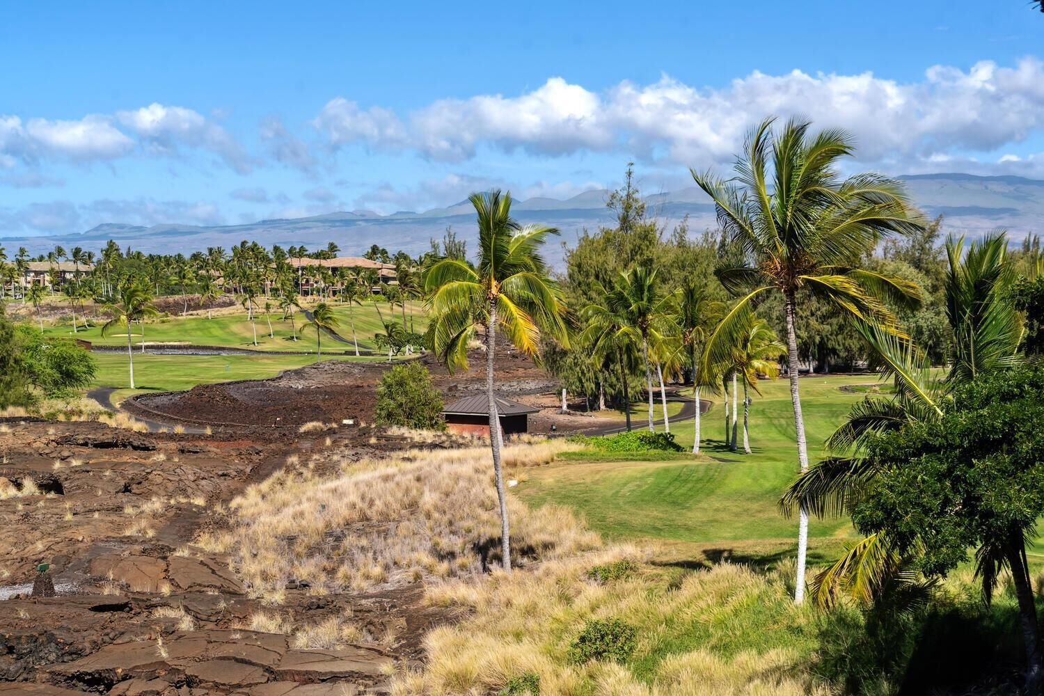 A golf course with a view of a mountain and a clear sky.