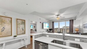 Una cocina moderna con lavavajillas, un ventanal con vistas y obras de arte en la pared.