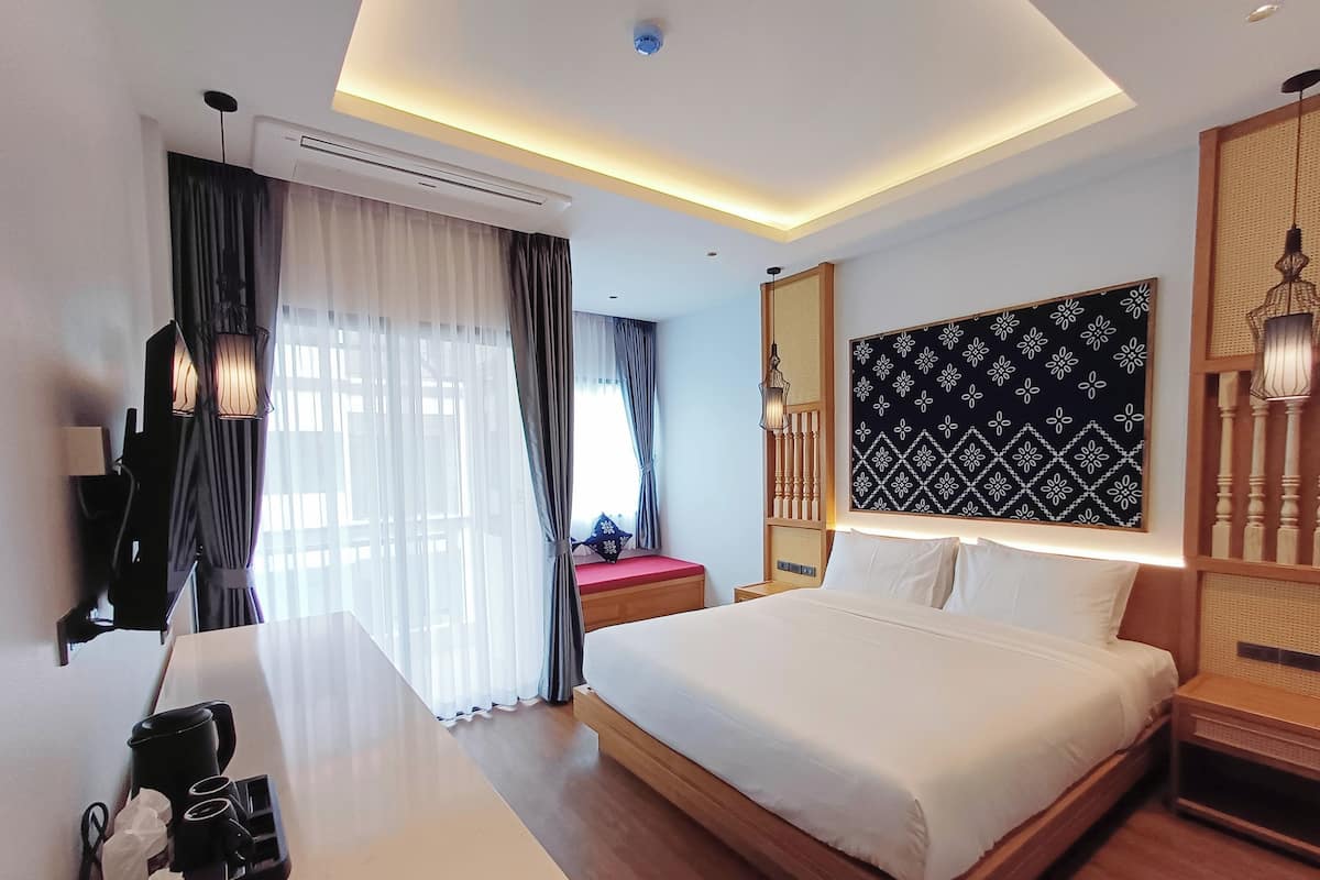 Ein modernes Hotelzimmer mit einem großen Bett, einem Schreibtisch und einem an der Wand befestigten Fernseher.