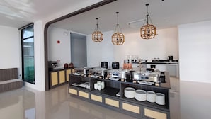 Una cocina moderna con una barra libre, que incluye una estación de café y varios recipientes de comida.