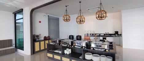 Una cocina moderna con una barra libre, que incluye una estación de café y varios recipientes de comida.