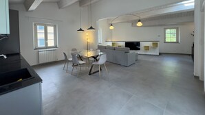 Un grand espace de vie comprenant une table à manger, un canapé et un coin cuisine.