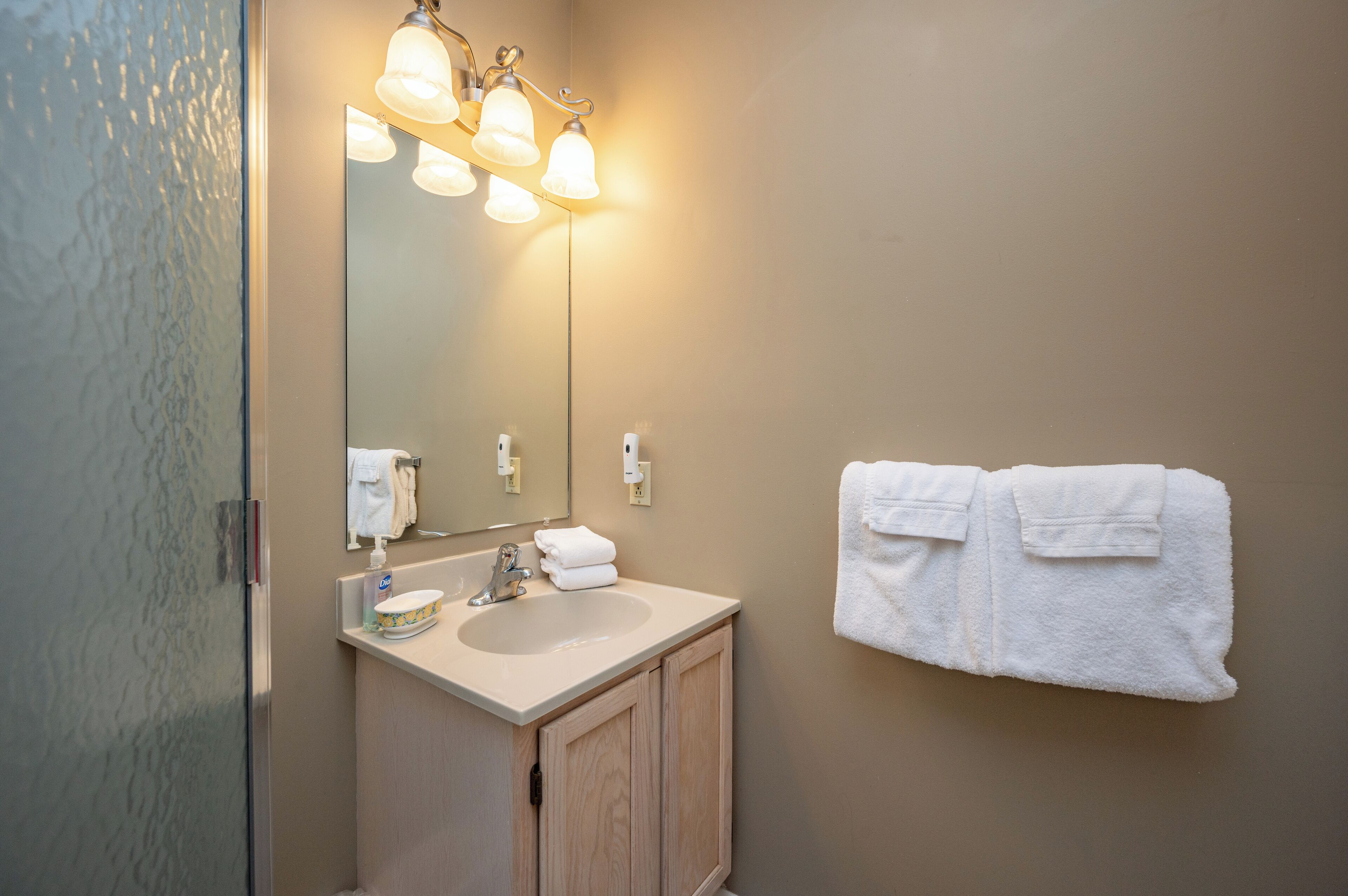 Une salle de bain équipée d’un lavabo, d’un miroir et d’un porte-serviettes.