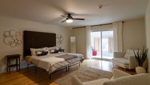 A bedroom with a bed, a ceiling fan, a window with curtains, a sofa, and a plant. - Family Friendly in Picton, PEC! (Prince Edward)