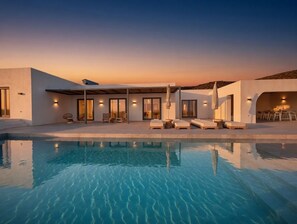 Ein moderner Poolbereich mit Pool, Liegestühlen und einer überdachten Sitzgelegenheit.