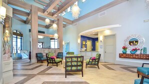 Un vestíbulo amplio con techos altos, vigas de madera y una mezcla de decoración moderna y tradicional.