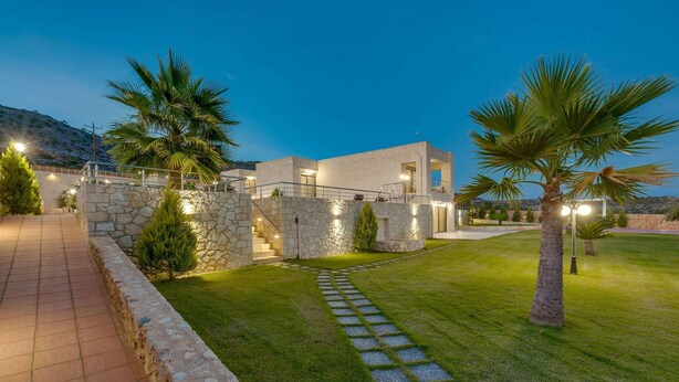 A modern house with stone walls, a paved pathway, and well-maintained grass. - Stone villa with private heated pool close to Marathi beach (Kounoupidiana)