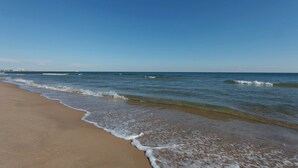 A beach with clear blue water and a sandy shore. - Camelot - Apartment (Oliva)