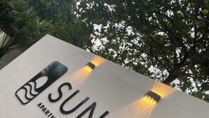 Sunset Apartment Beach Residences -niminen kohde, jonka kyltissä on moderni muotoilu ja valaistut kirjaimet.
