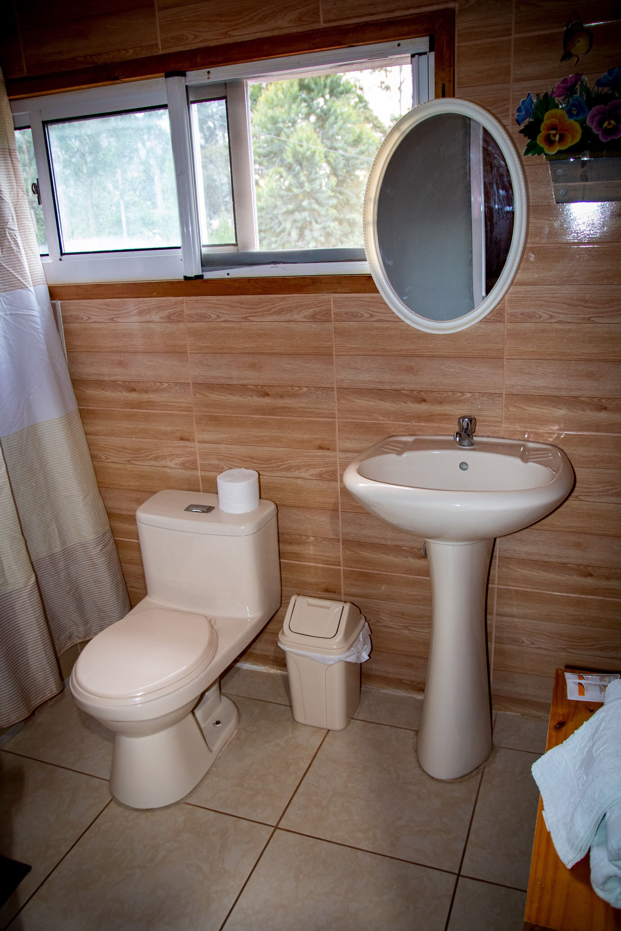 Een badkamer met toilet, wastafel en raam.