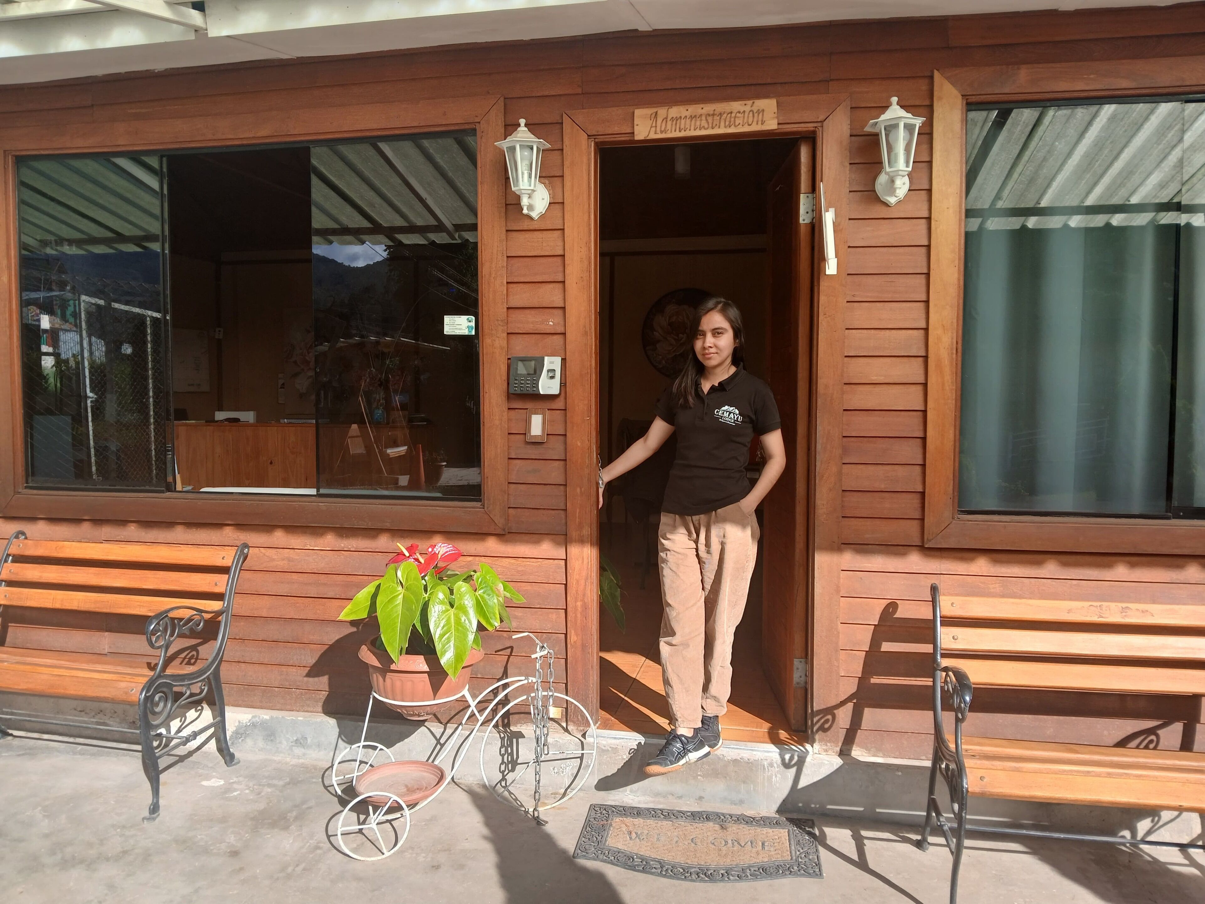 A wooden building with a sign reading "Administracion" and a person standing at the entrance.