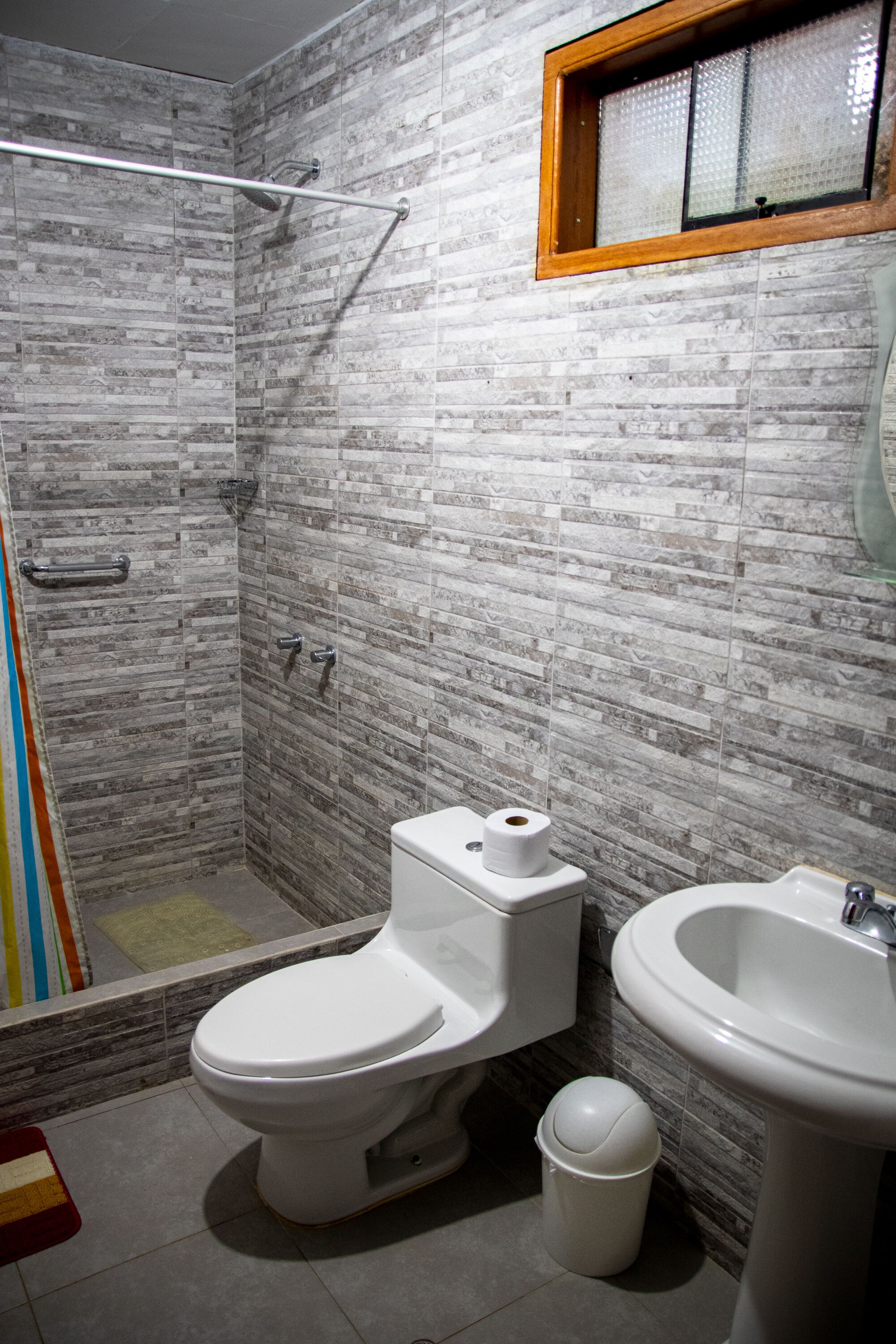 A bathroom with a shower, toilet, and sink.