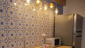 A kitchen with a wooden countertop, stainless steel sink, a microwave, and a refrigerator. - Cozy studio apartment within walking distance of the Archaeological Excavations of Pompeii (Scafati)