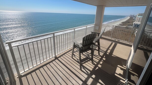 Un balcon avec vue sur la plage et l’océan.