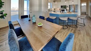 Una cucina moderna con isola centrale, sgabelli da bar e illuminazione a sospensione.