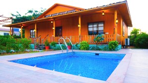 A wooden house with a swimming pool, a wooden deck, and a fence. - Aanandam Resort and Spa Pushkar (Pushkar)