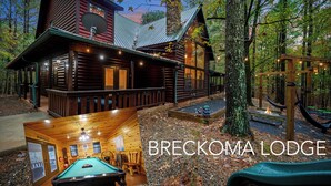 Un chalet en bois doté d’une table de billard, d’une terrasse et d’une balançoire.