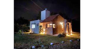 Ein modernes Haus mit Naturstein-Fassade, rotem Ziegeldach und einer gut beleuchteten Eingangspartei.