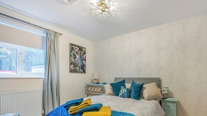 A bedroom with a bed, a nightstand, a window, and a radiator. - 1 bedroom accommodation in Coleford (Coleford)